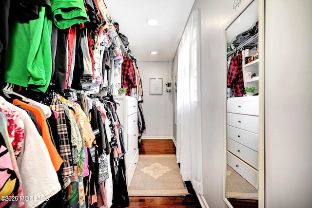 walk in closet with wood finished floors