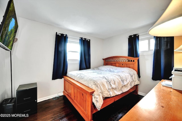 bedroom with baseboards, dark wood-style floors, and multiple windows