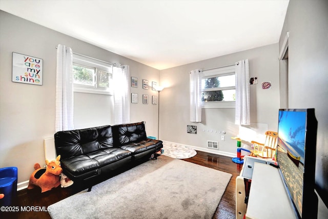 living room with baseboards, wood finished floors, and visible vents