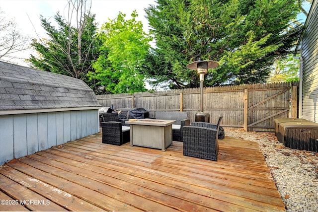 deck featuring a gate, an outdoor fire pit, and fence