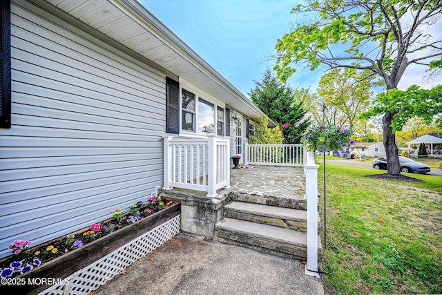view of exterior entry with a yard