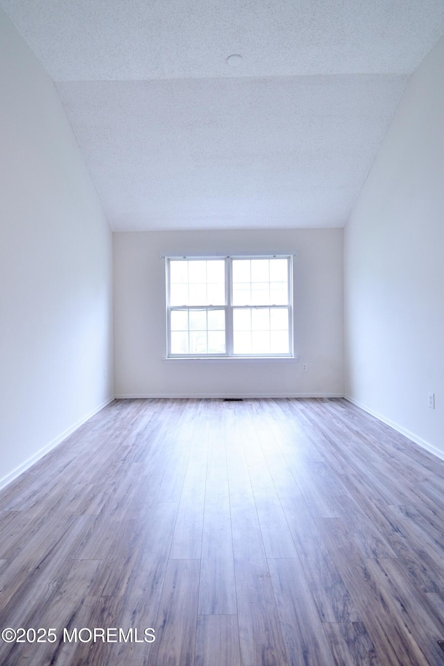 111 Watson Ct, Howell, NJ 07731 - spare room with wood finished floors, baseboards, a textured ceiling, and lofted ceiling