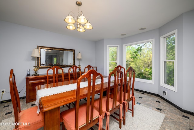 dining space featuring a chandelier and baseboards