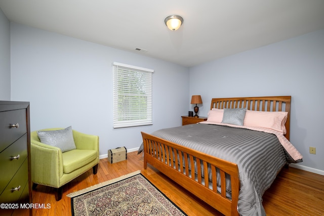 bedroom featuring baseboards and wood finished floors