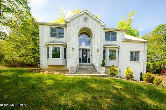 view of front of property featuring brick siding and a front lawn