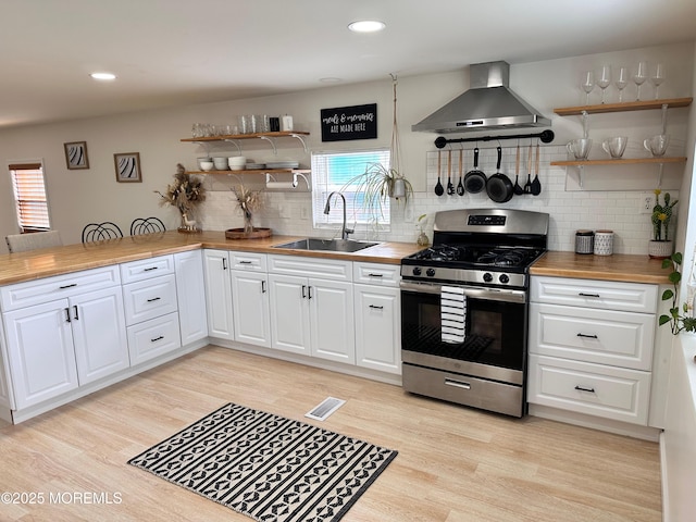 7 Misty Ln, Jackson, NJ 08527 - kitchen featuring wall chimney range hood, visible vents, stainless steel range with gas stovetop, open shelves, and a sink