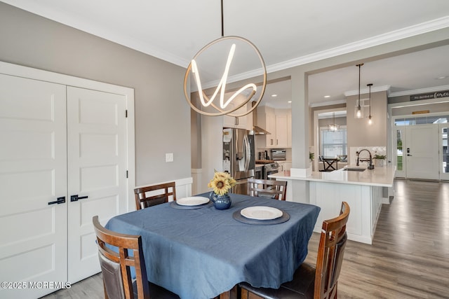 dining space featuring ornamental molding, wood finished floors, and a notable chandelier