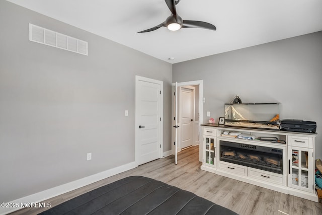 bedroom featuring light wood-style floors, baseboards, a ceiling fan, and visible vents