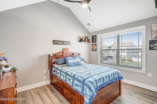 bedroom with light wood-type flooring, baseboards, and lofted ceiling