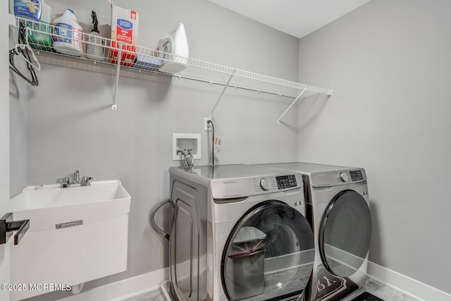 laundry room with independent washer and dryer, laundry area, baseboards, and a sink
