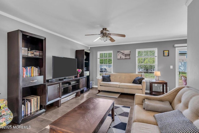 living area with crown molding, ceiling fan, baseboards, and wood finished floors