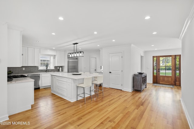 196 Highwood Rd, Oakhurst, NJ 07755 - kitchen with a kitchen island, white cabinets, a sink, light wood-style flooring, and appliances with stainless steel finishes