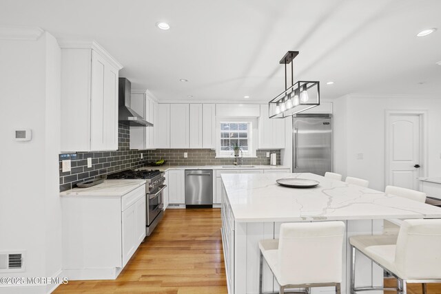 196 Highwood Rd, Oakhurst, NJ 07755 - kitchen with visible vents, high end appliances, a breakfast bar, wall chimney exhaust hood, and a sink