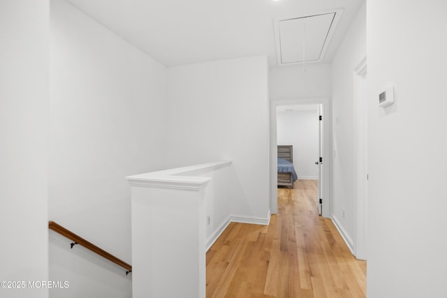 196 Highwood Rd, Oakhurst, NJ 07755 - hall with baseboards, an upstairs landing, attic access, and light wood-type flooring