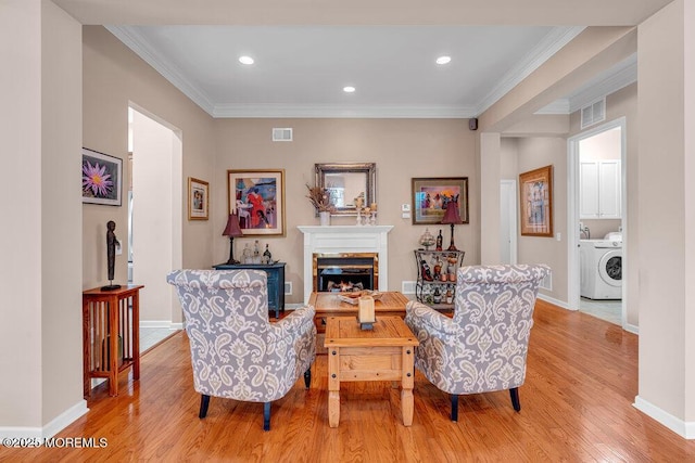 sitting room with a fireplace, light wood-style flooring, ornamental molding, baseboards, and recessed lighting