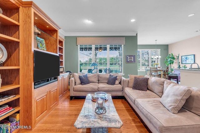 living area with light wood-style flooring, ornamental molding, and recessed lighting