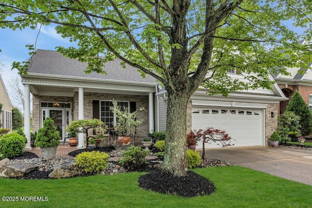 view of front of property with driveway, a front lawn, a garage, brick siding, and covered porch