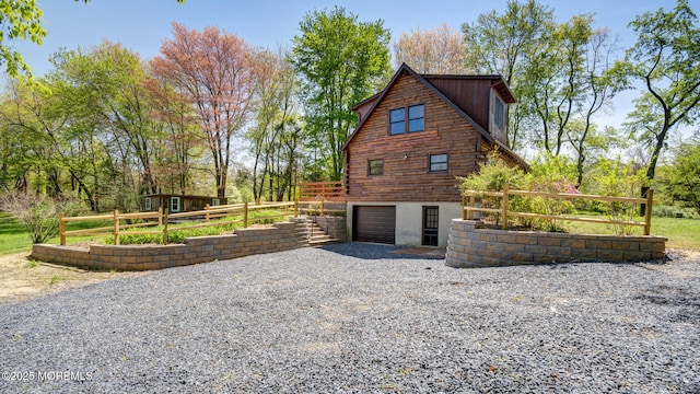 156 Baird Rd, Millstone, NJ 08535 - view of home's exterior with an attached garage, fence, log siding, and gravel driveway