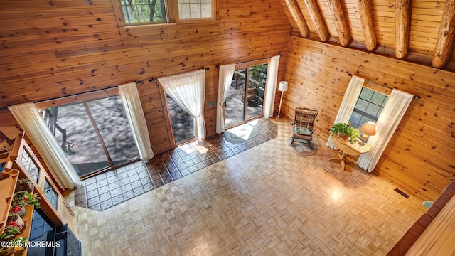 156 Baird Rd, Millstone, NJ 08535 - unfurnished living room featuring wood walls, visible vents, and a towering ceiling