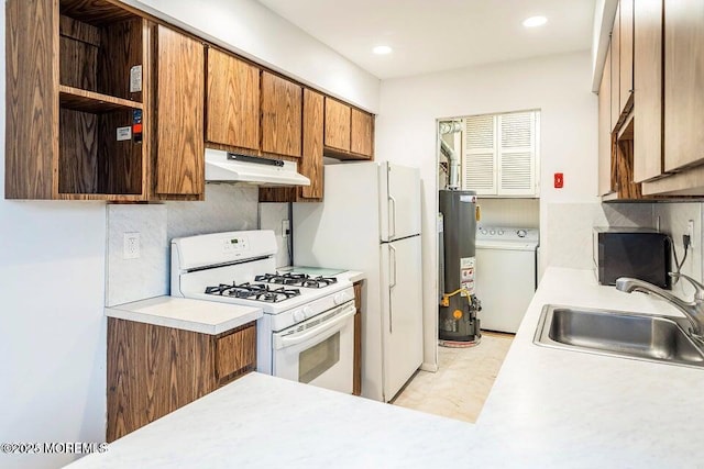 kitchen featuring washer / clothes dryer, white gas range, under cabinet range hood, a sink, and water heater