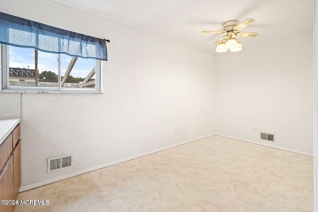 spare room with tile patterned floors, ceiling fan, baseboards, and visible vents