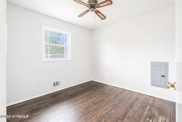 empty room featuring ceiling fan, electric panel, visible vents, wood finished floors, and baseboards