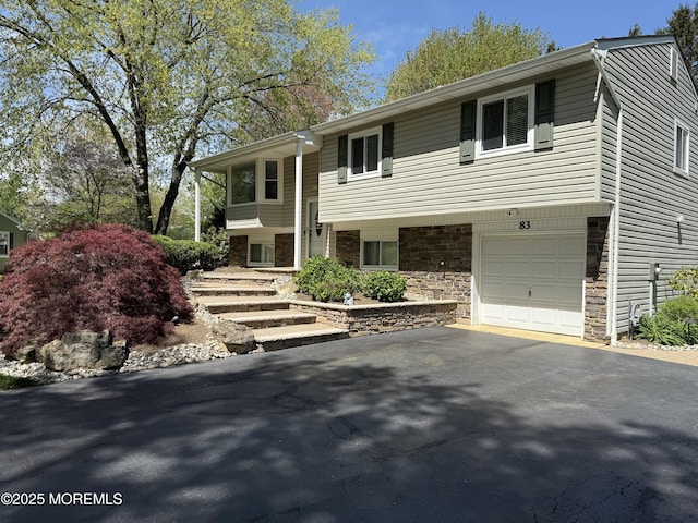 83 Campbell Ct, Freehold, NJ 07728 - raised ranch featuring driveway, a garage, and stone siding