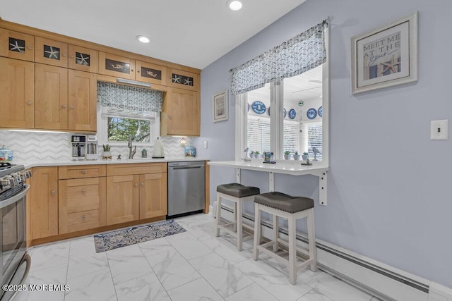 kitchen with a sink, light countertops, stainless steel appliances, decorative backsplash, and glass insert cabinets