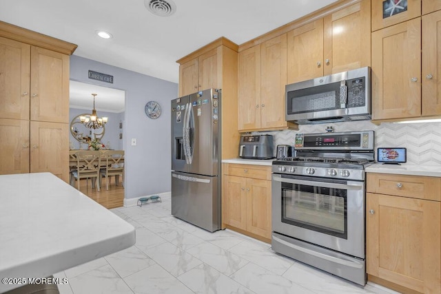 kitchen featuring a notable chandelier, appliances with stainless steel finishes, light countertops, marble finish floor, and visible vents