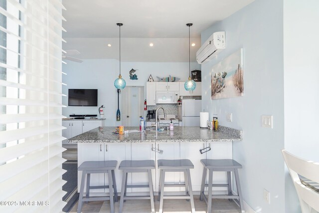 28 E Marlin Way, Lavallette, NJ 08735 - kitchen with a peninsula, white cabinets, white appliances, and a wall mounted air conditioner
