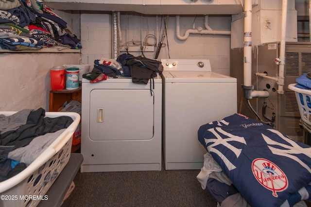 laundry room featuring concrete block wall, laundry area, and washer and clothes dryer
