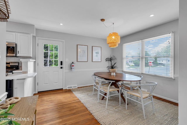 dining area with light wood-style floors, recessed lighting, and baseboards