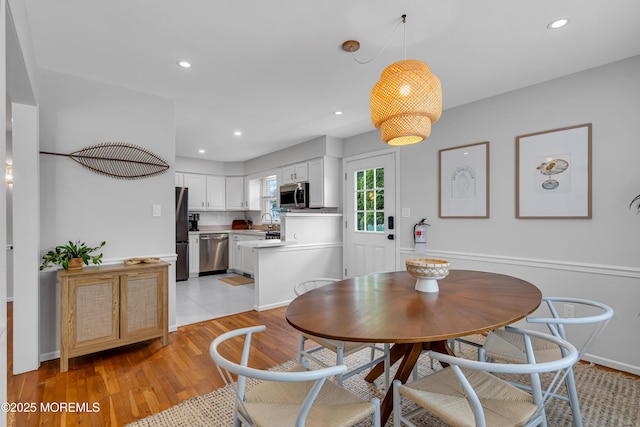 dining area with light wood-style flooring, recessed lighting, and baseboards