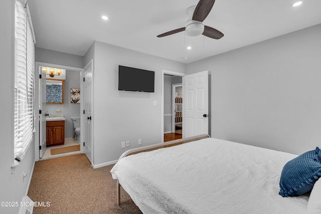 bedroom featuring recessed lighting, light carpet, baseboards, a sink, and ensuite bathroom