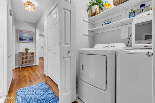 laundry area with washing machine and dryer and light wood-style floors