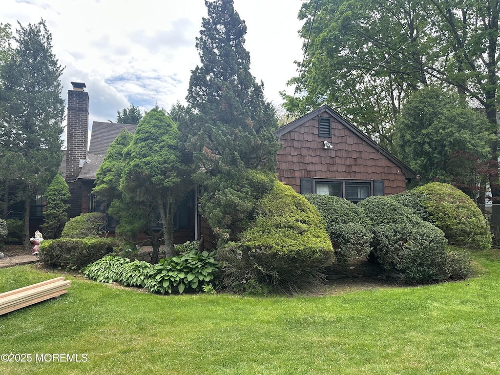 view of home's exterior featuring a yard and a chimney
