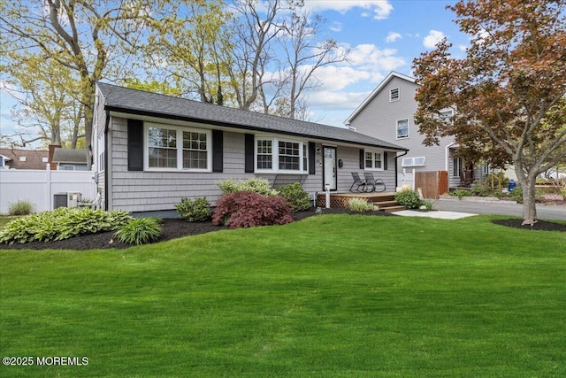 view of front of home featuring central air condition unit, a front lawn, and fence