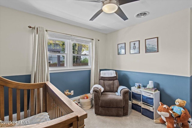 carpeted bedroom with a nursery area, visible vents, and a ceiling fan