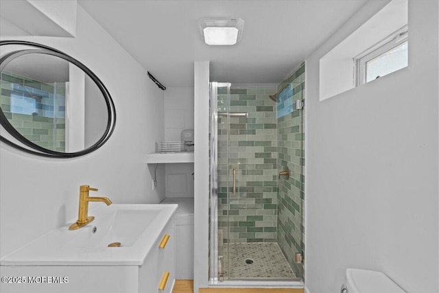 full bathroom with a stall shower, vanity, and toilet