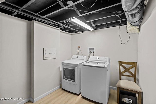 laundry room featuring separate washer and dryer, baseboards, and light wood-type flooring