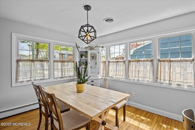 dining space featuring baseboards, a baseboard radiator, visible vents, and wood finished floors