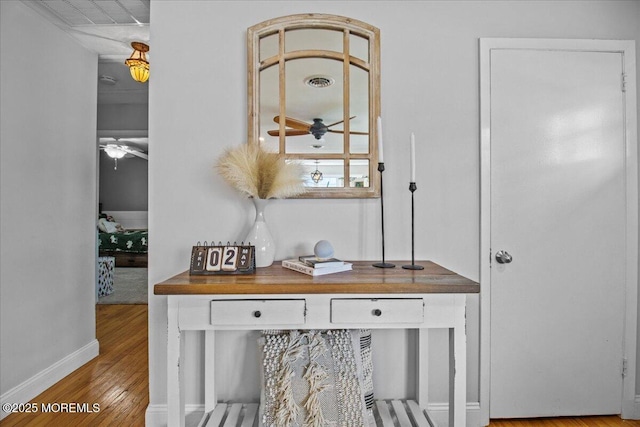 interior space with baseboards, visible vents, ceiling fan, and wood finished floors