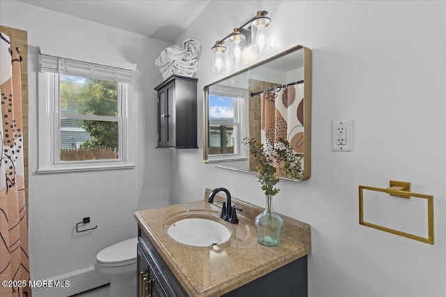 bathroom featuring toilet, vanity, and a shower with curtain