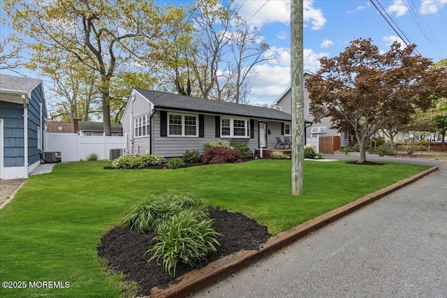 single story home featuring central air condition unit, a front yard, and fence
