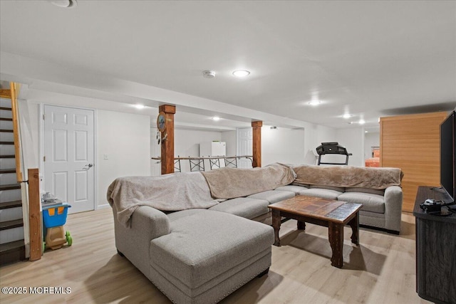 living room featuring stairs and light wood-style floors