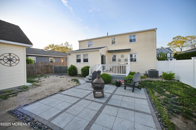 back of house featuring central AC unit, a patio area, and a fenced backyard