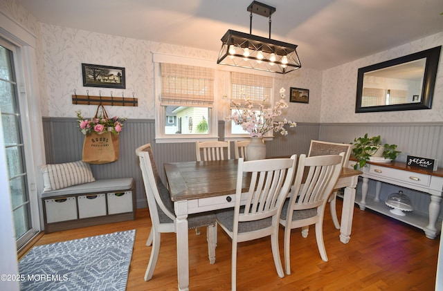 dining area featuring a notable chandelier, wainscoting, and wallpapered walls
