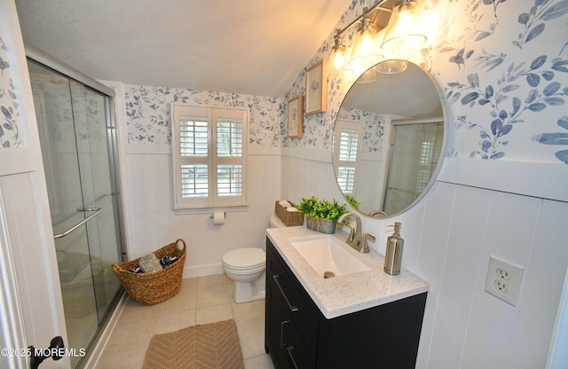 full bath with wallpapered walls, a stall shower, a wainscoted wall, and vanity