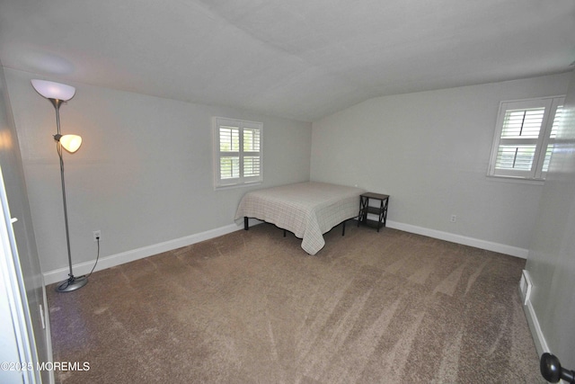 unfurnished bedroom featuring baseboards, carpet floors, and vaulted ceiling