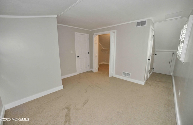 unfurnished bedroom featuring baseboards, ornamental molding, visible vents, and light colored carpet